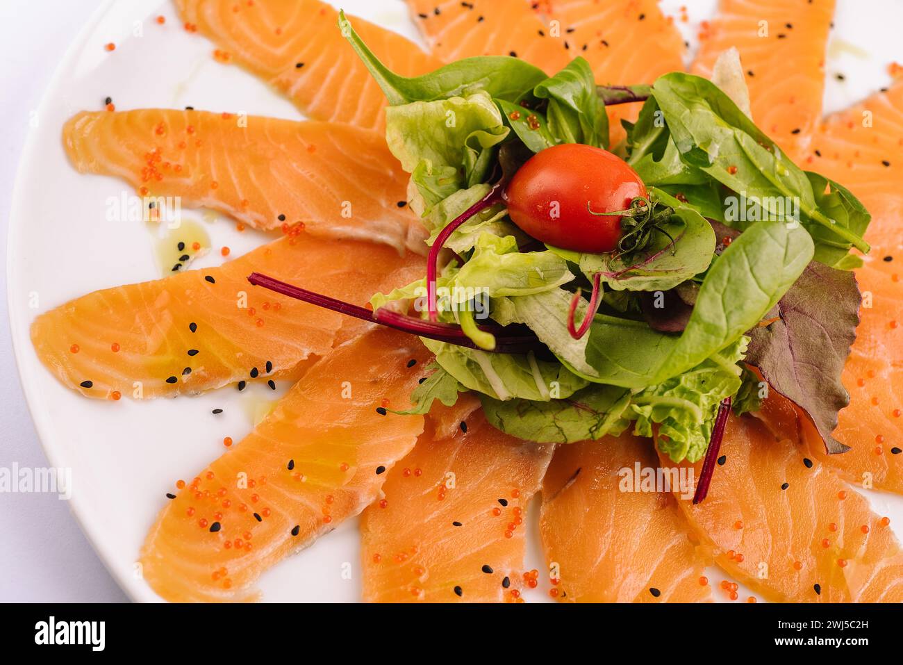 Tranches de filet de saumon cru sur assiette blanche Banque D'Images