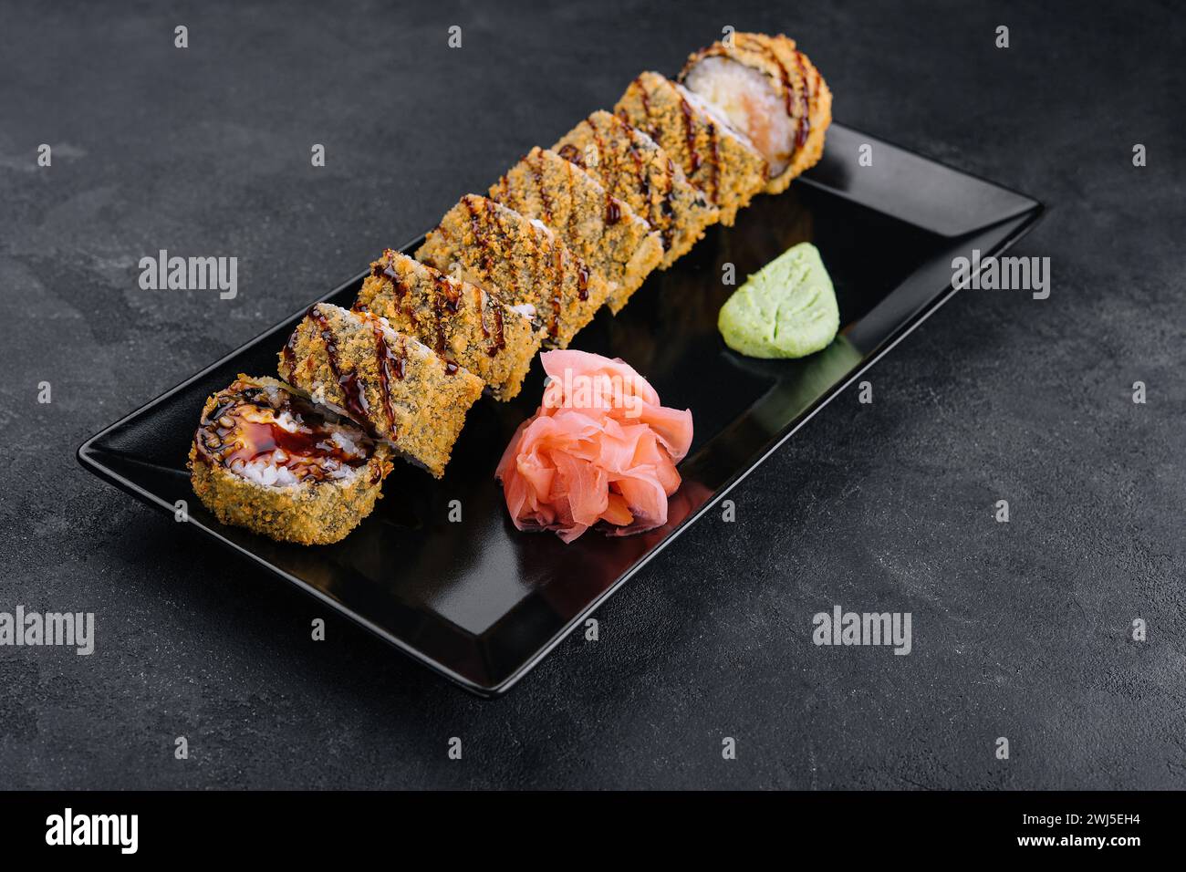 Servi sushi chaud avec gingembre et wasabi sur une assiette en pierre noire Banque D'Images