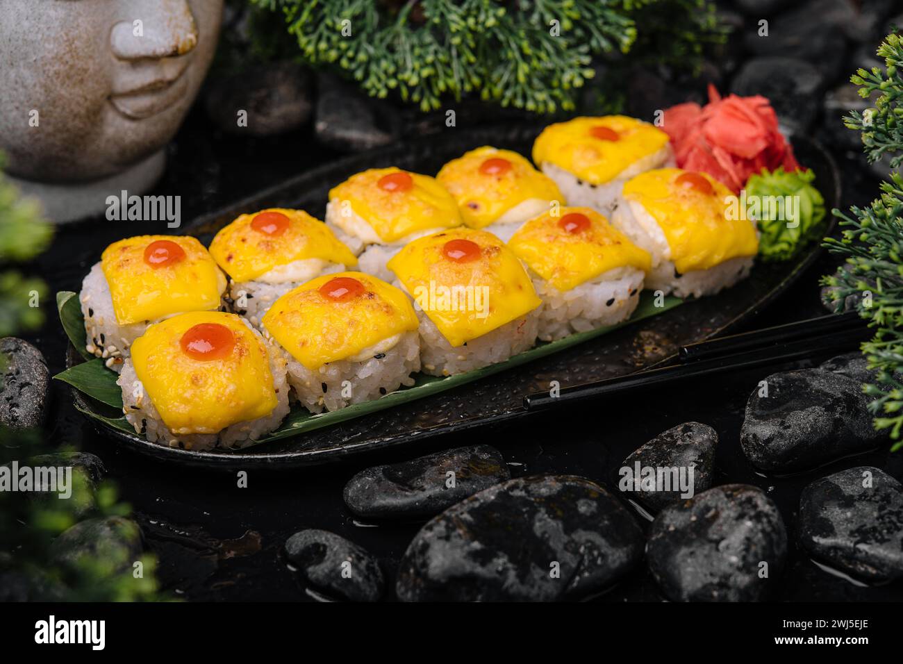 Sushi avec fromage cheddar sur plateau noir avec curry jaune Banque D'Images