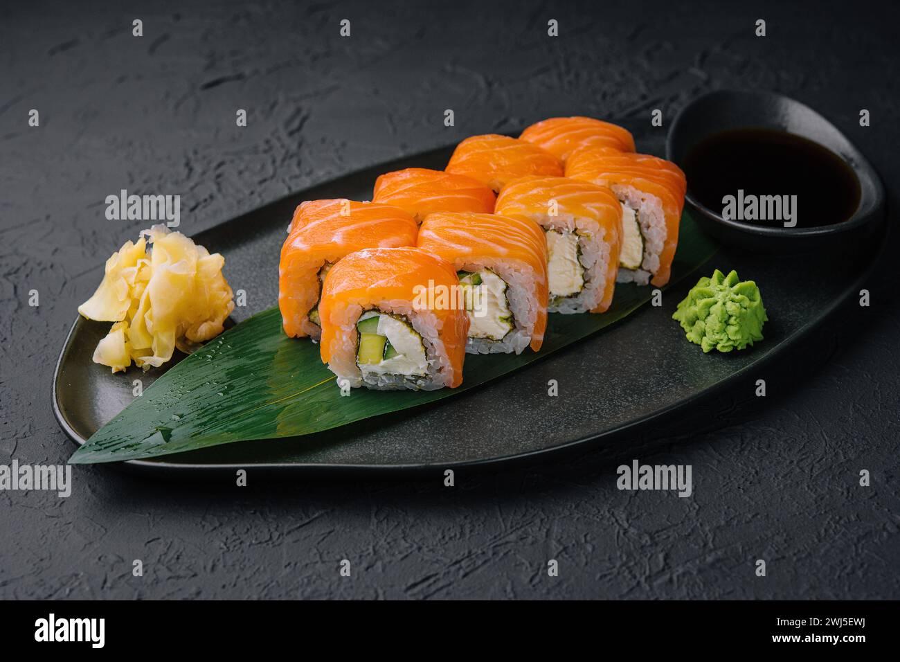 Délicieux sushi philadelphia frais sur assiette noire Banque D'Images