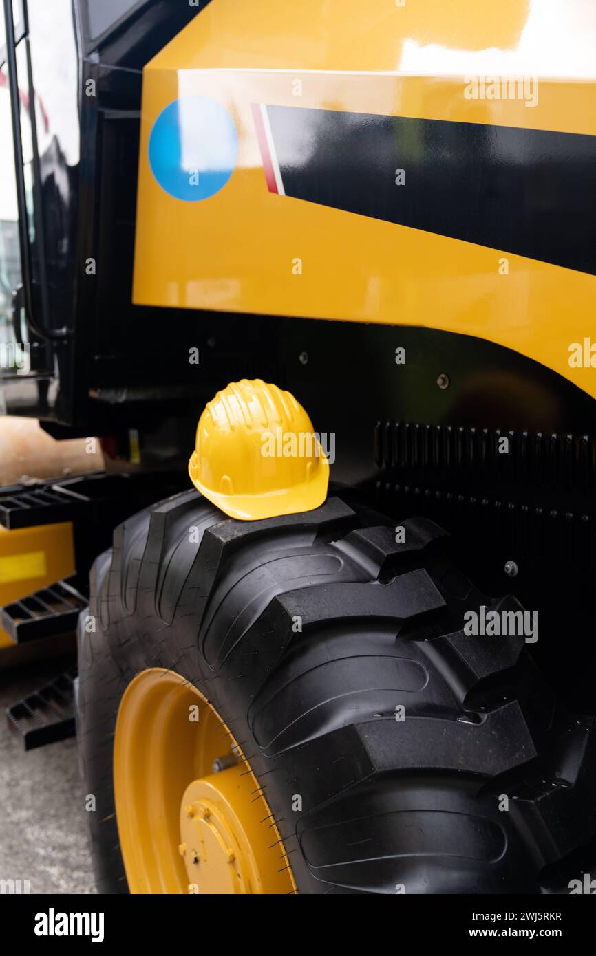 Un casque jaune repose sur le volant d'un engin de chantier. Banque D'Images