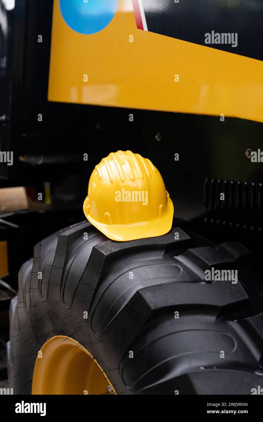 Un casque jaune repose sur le volant d'un engin de chantier. Banque D'Images