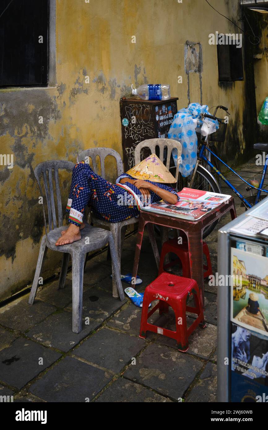 Jan 2024, personne avec des chapeaux coniques vietnamiens faisant une sieste dans la ville antique de Hoi an Banque D'Images