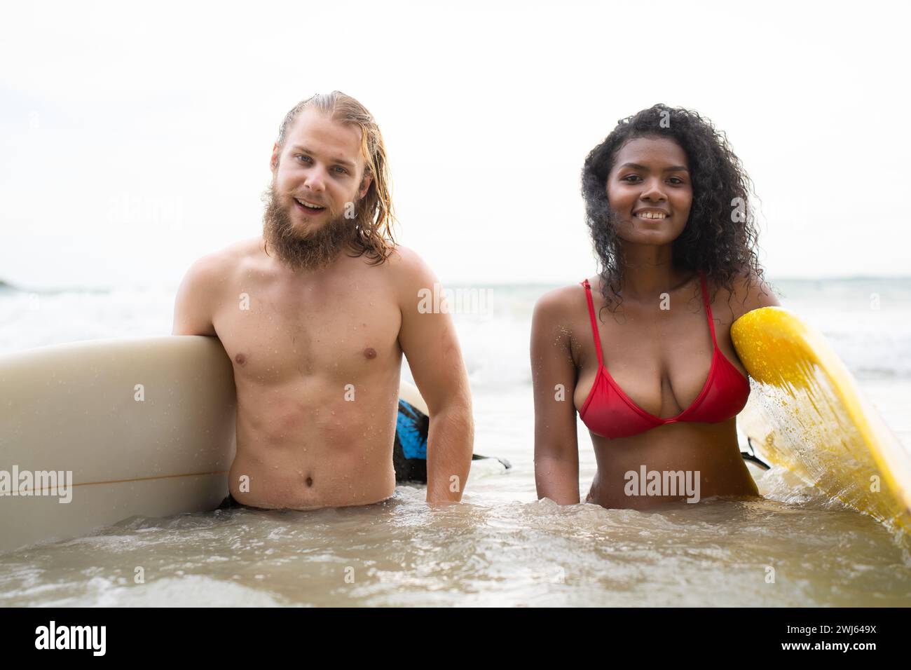 Jeune couple de surfeurs avec planche de surf sur la plage Banque D'Images