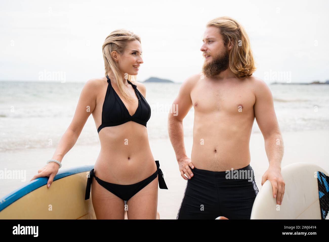 Jeune couple de surfeurs avec planche de surf sur la plage Banque D'Images