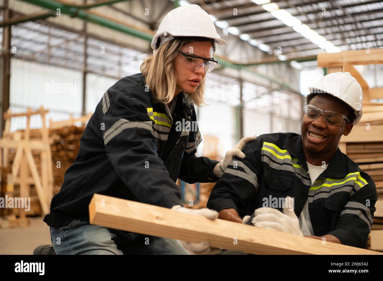 Travailleur d'entrepôt de bois blessé à la jambe, les collègues aident et soutiennent pour aller à la salle de premiers soins pour le traitement. Banque D'Images