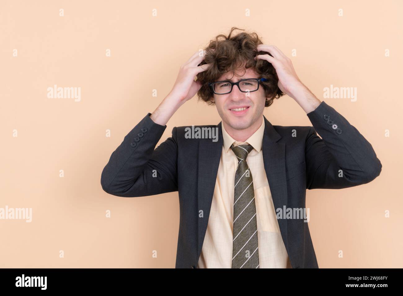 Portrait d'un beau jeune homme avec des cheveux bouclés sur un fond beige Banque D'Images