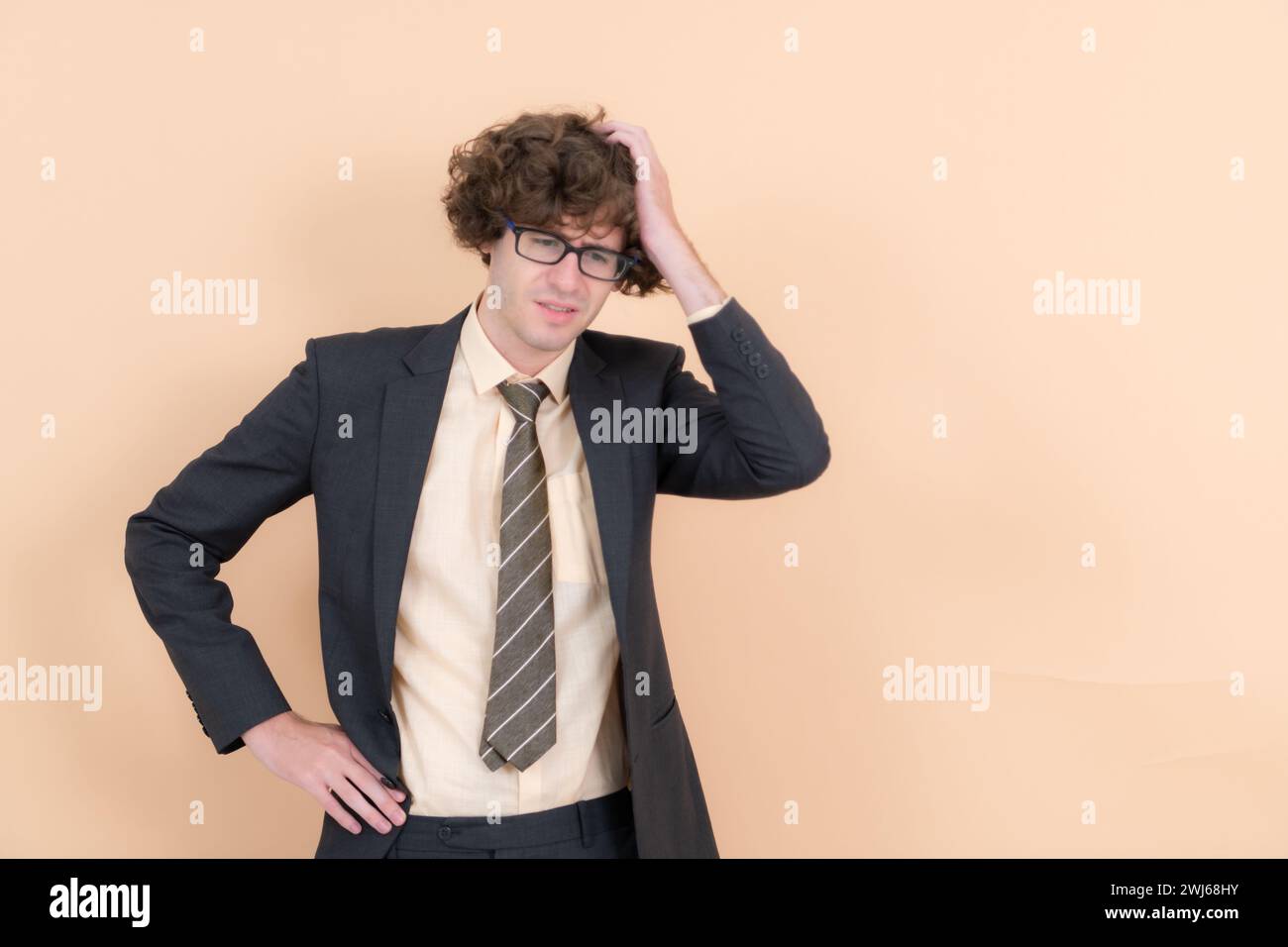 Portrait d'un beau jeune homme avec des cheveux bouclés sur un fond beige Banque D'Images