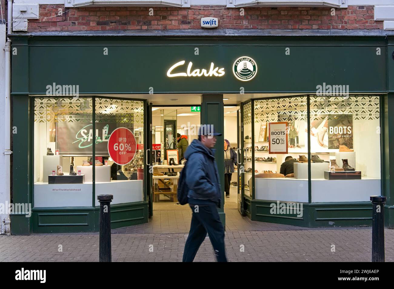 Boutique de chaussures Clarks avec une personne aux mouvements flous marchant sur la High Street à Lincoln. Lincolnshire, Banque D'Images