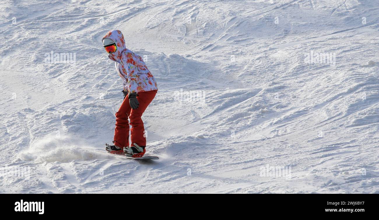 Une femme snowboarder invitant à glisser sur Mount Snow seule. Banque D'Images