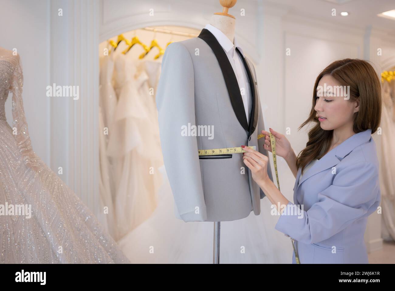 Les créateurs de mode asiatiques s'assurent que la tenue du marié est absolument précise et prête pour la mariée et le marié à essayer. Banque D'Images