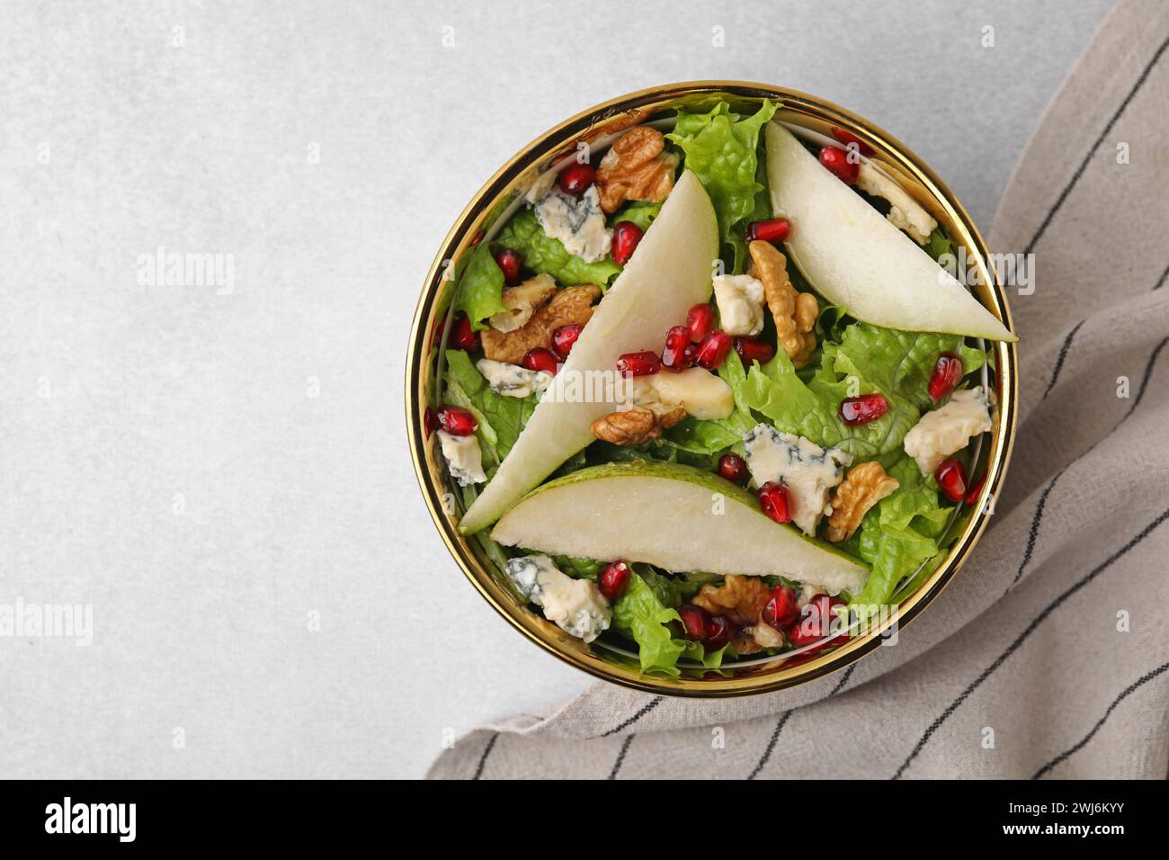 Délicieuse salade de poires dans un bol sur une table lumineuse, vue de dessus. Espace pour le texte Banque D'Images