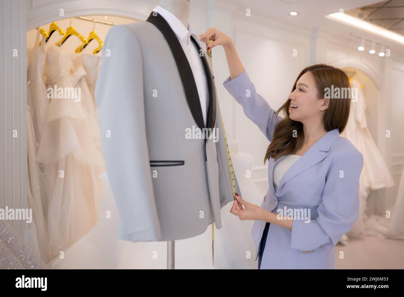 Les créateurs de mode asiatiques s'assurent que la tenue du marié est absolument précise et prête pour la mariée et le marié à essayer. Banque D'Images