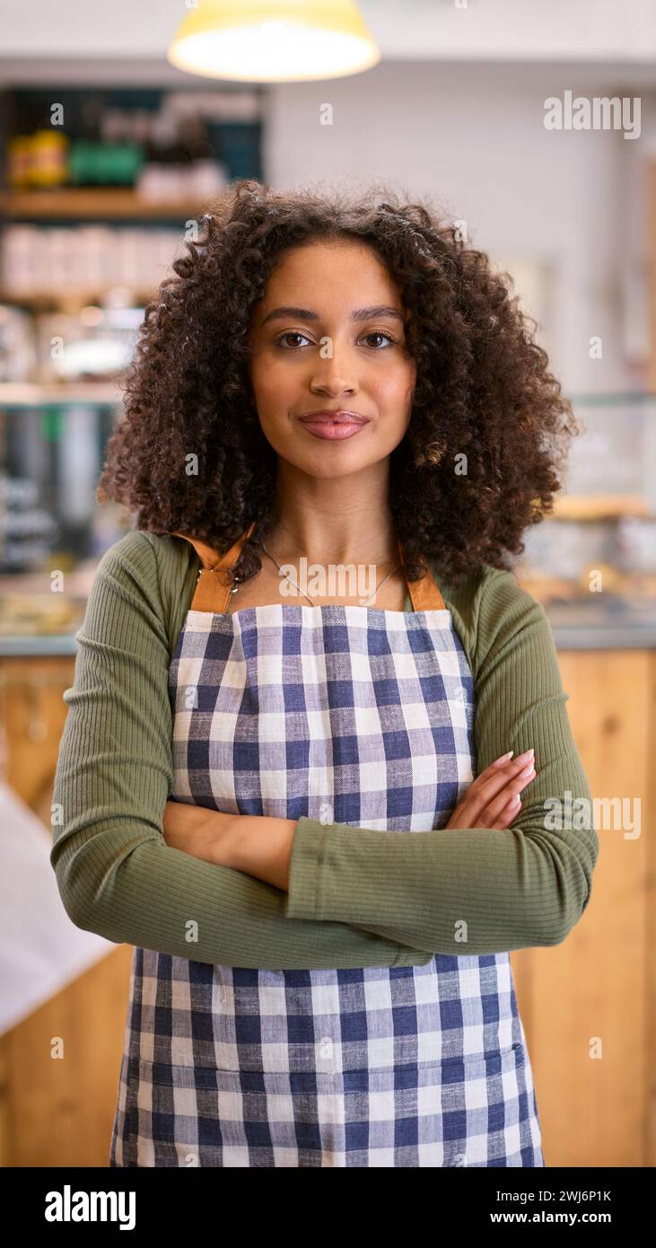 Portrait de jeune femme confiante portant tablier travaillant dans un magasin d'alimentation Banque D'Images
