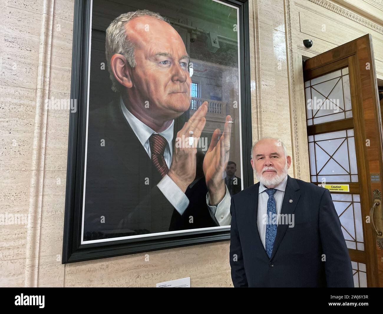 Le député Francie Molloy, à côté d'un portrait de Martin McGuinness dans le Great Hall of Parliament Buildings, Stormont, alors qu'il annonçait qu'il ne se présenterait pas à une réélection dans la circonscription de Mid Ulster lors des prochaines élections générales britanniques. Date de la photo : mardi 13 février 2024. Banque D'Images