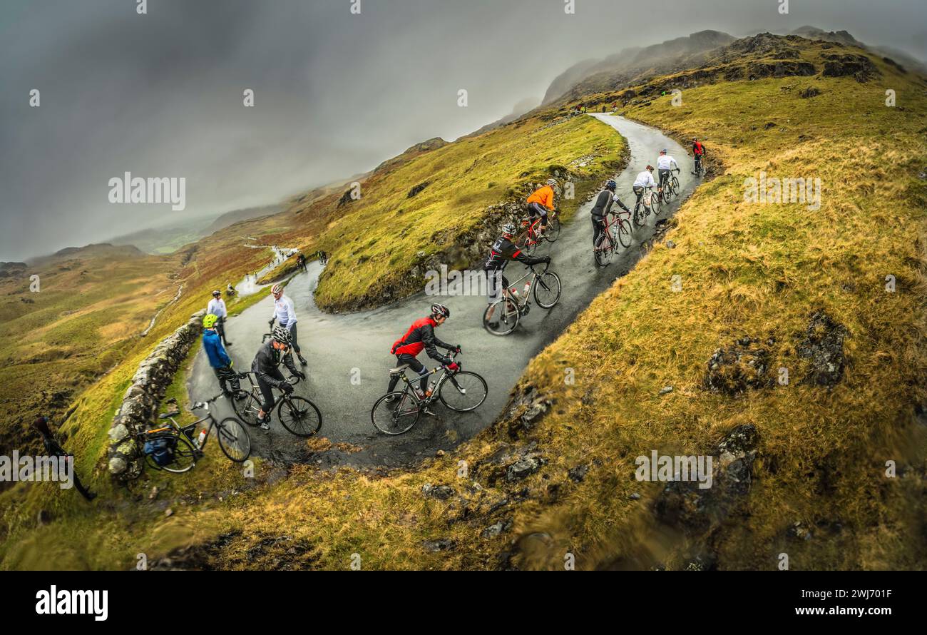 Une journée très humide dans le Lake District pour les coureurs du défi cycliste Fred Whitton 2013, vu ici sur Hardknott Pass, la route la plus escarpée d'Angleterre. Banque D'Images