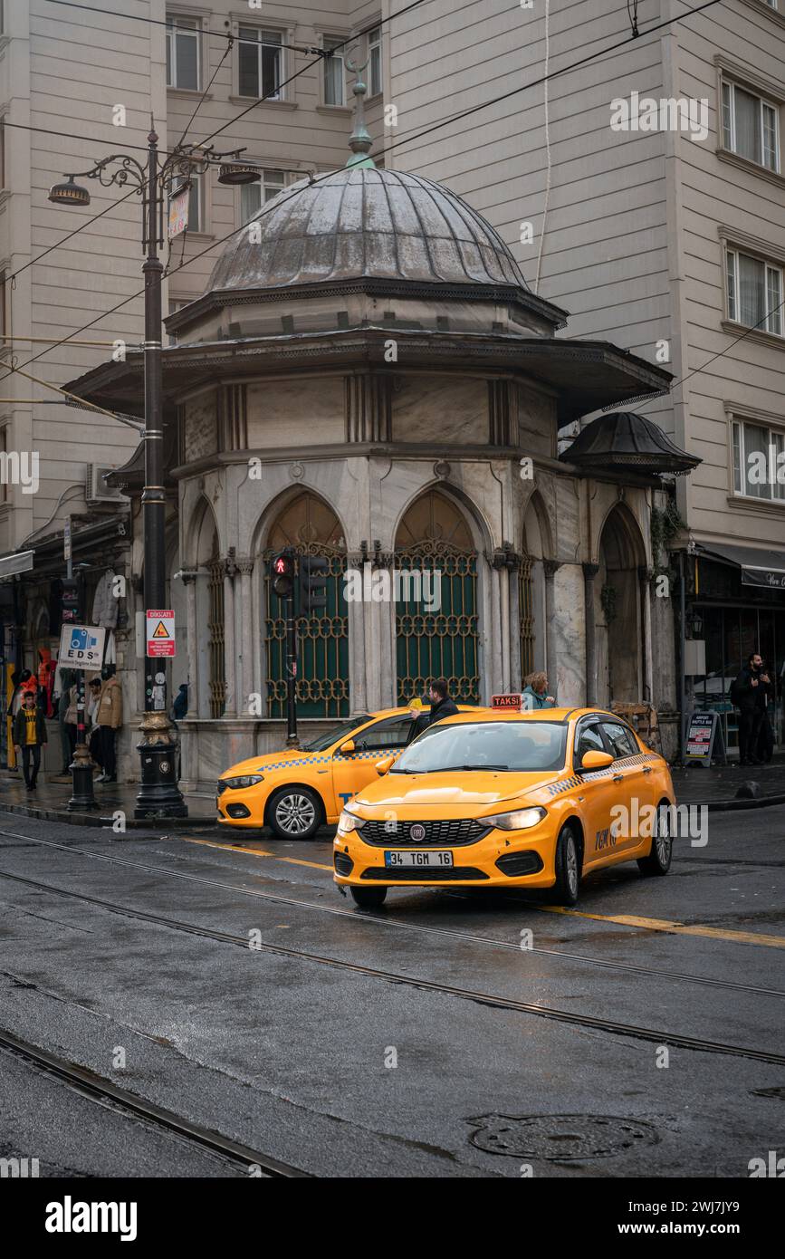 Navigation sous la pluie : les taxis illuminent les rues pavées d'Istanbul Banque D'Images