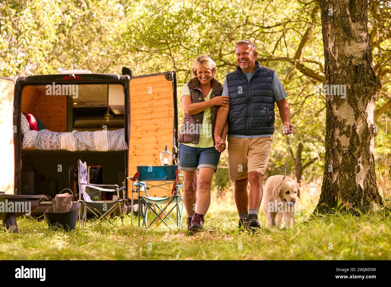 Couple senior Camping à la campagne avec RV prenant Labrador Dog pour Une promenade Banque D'Images