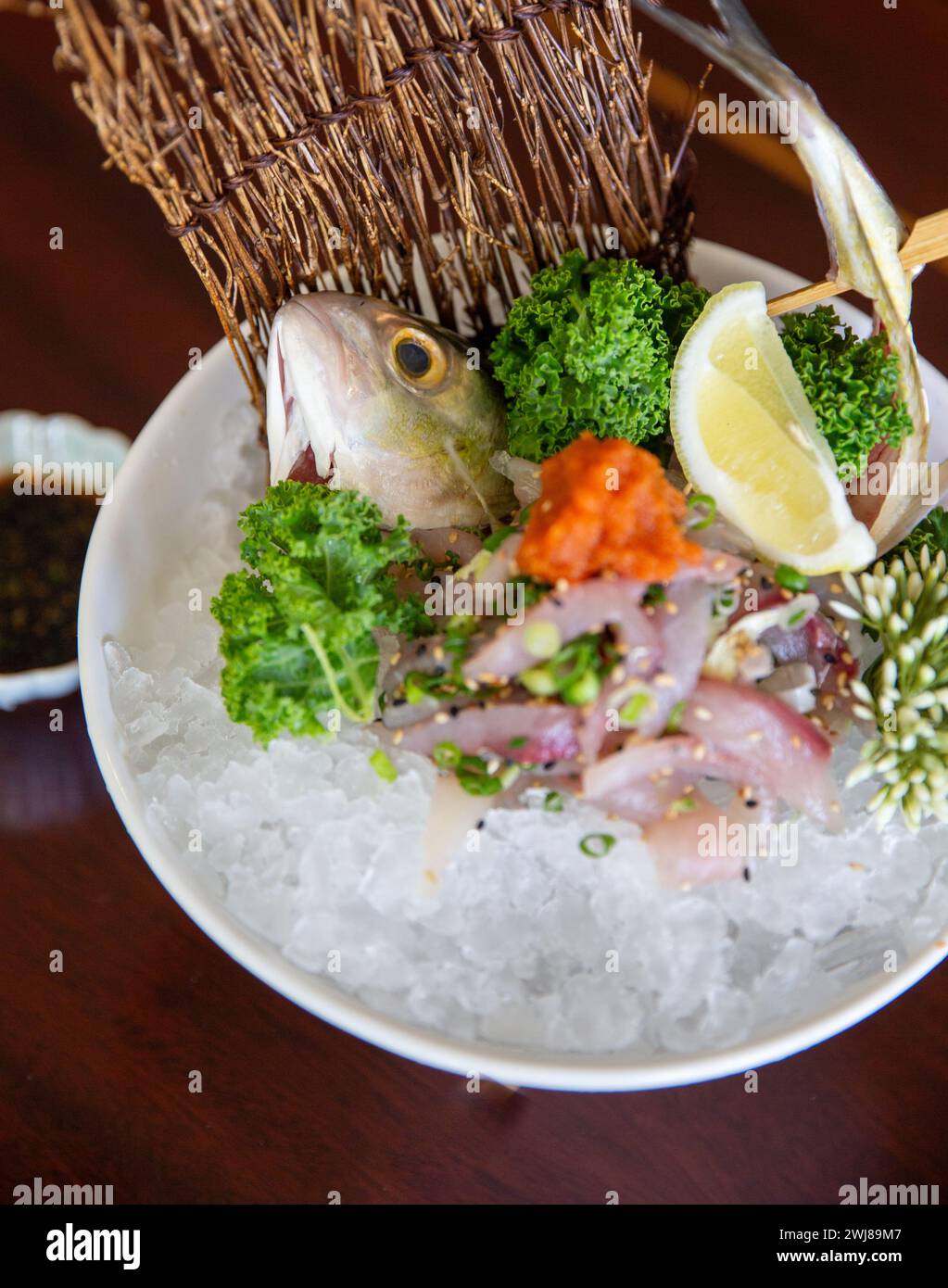 Tête de poisson morte dans une assiette de sashimi Banque D'Images