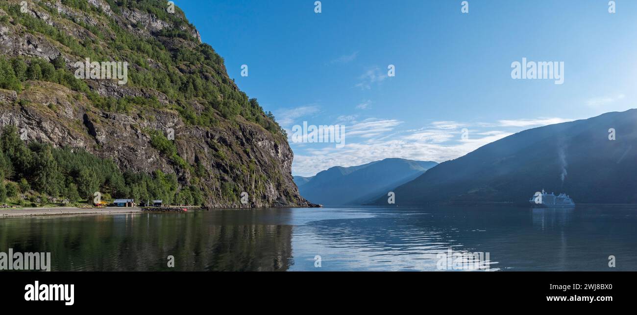 Vue panoramique matinale des rayons du soleil sur l'Aurlandsfjord vu du bord de l'eau à Flåm, Norvège. Banque D'Images