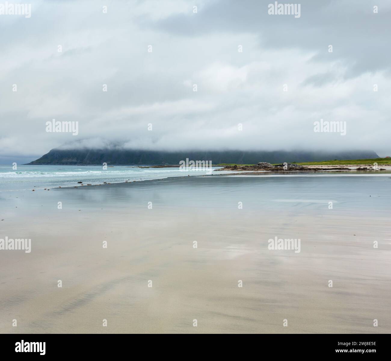 Misty d'été et nuageux vue de la plage de sable blanc et le ciel des reflets dans Ramberg (Norvège, îles Lofoten). Banque D'Images