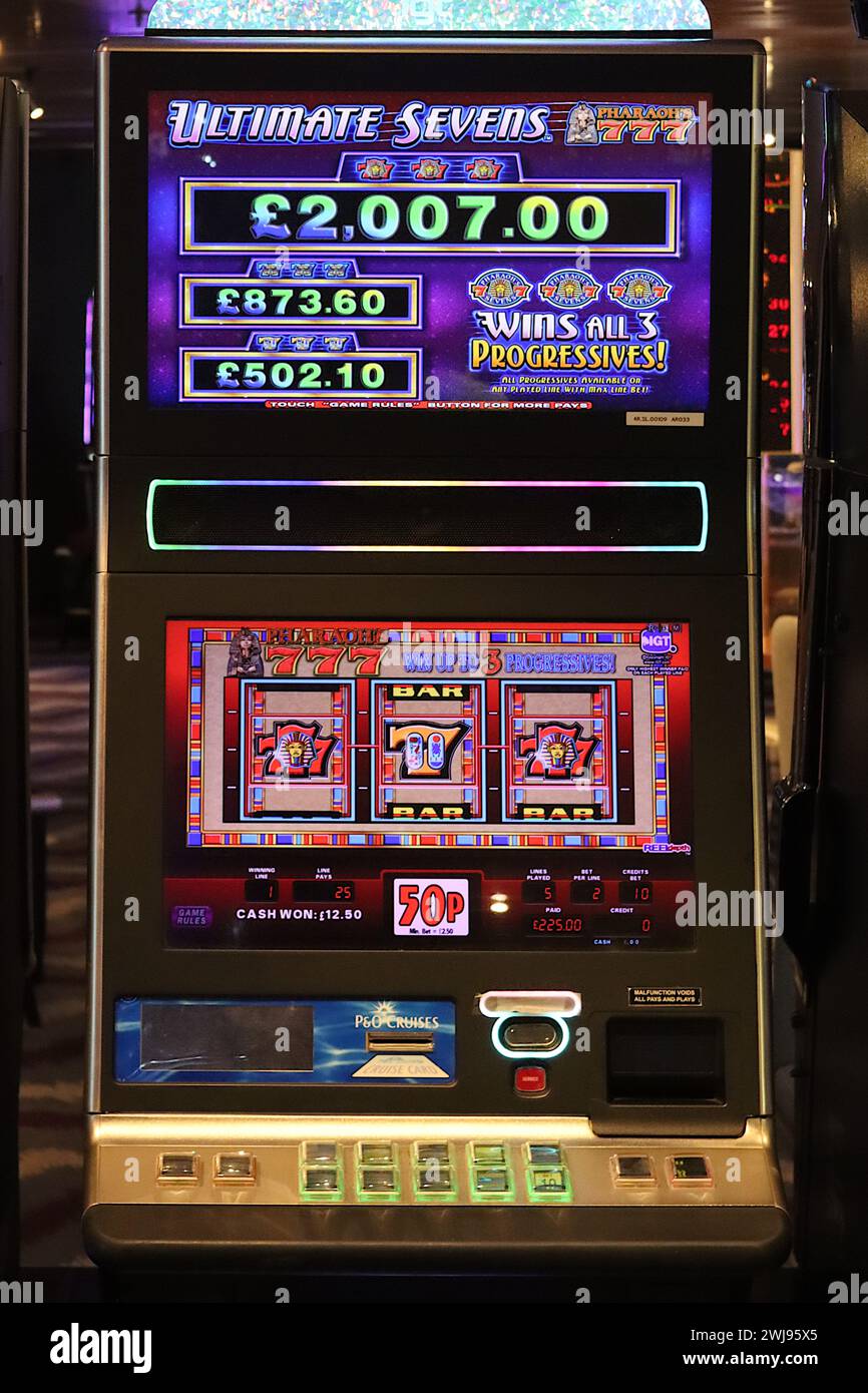 Ultimate Sevens machine à sous vidéo avec panneaux lumineux colorés, panneau d'en-tête et icônes graphiques ne dispose que de trois rouleaux tournants. Banque D'Images