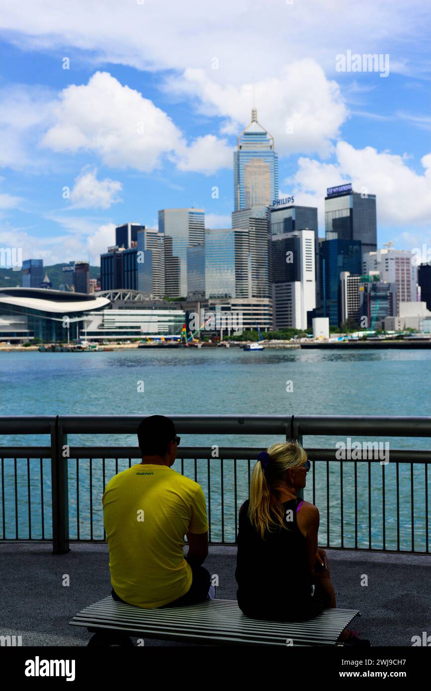 Un couple profitant de la vue sur le port Victoria et Wan Chai à Hong Kong. Banque D'Images