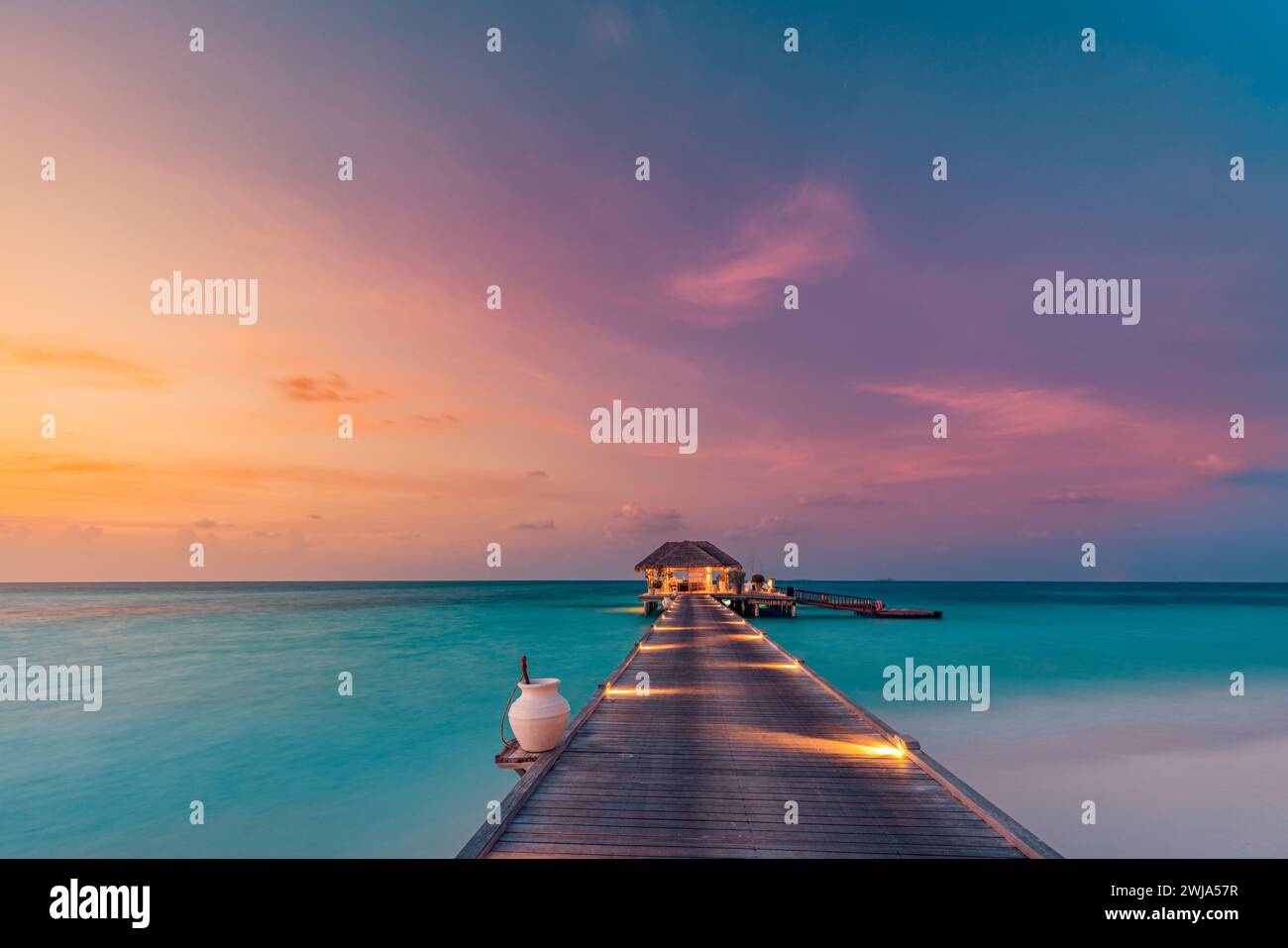 Belle côte de plage de coucher de soleil. Ciel coloré nuages de rayons de soleil sur la silhouette des palmiers. Paysage insulaire panoramique, reflets calmes de la mer se détendre tropical Banque D'Images