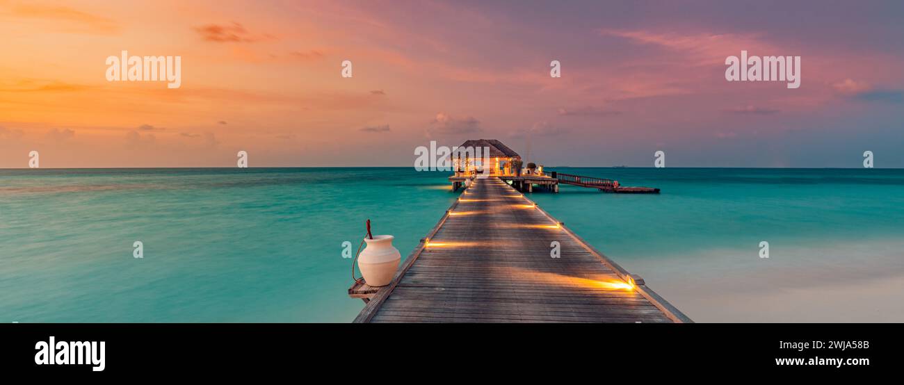 Belle côte de plage de coucher de soleil. Ciel coloré nuages de rayons de soleil sur la silhouette des palmiers. Paysage insulaire panoramique, reflets calmes de la mer se détendre tropical Banque D'Images