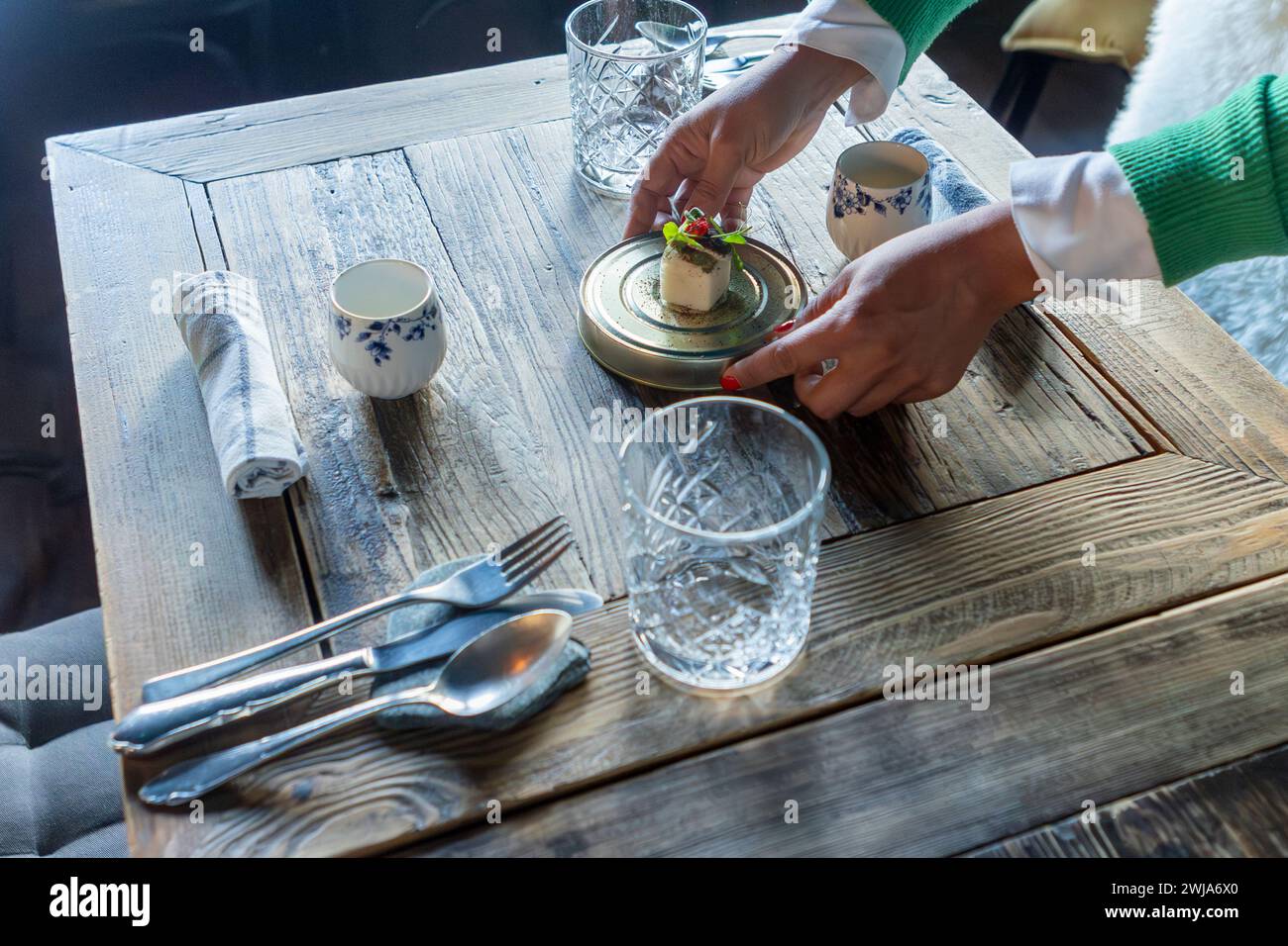 Une personne méconnaissable recadrée profite d'un plat gastronomique magnifiquement présenté dans un restaurant étoilé Michelin à Zermatt, en Suisse, mettant en valeur la fusion Banque D'Images