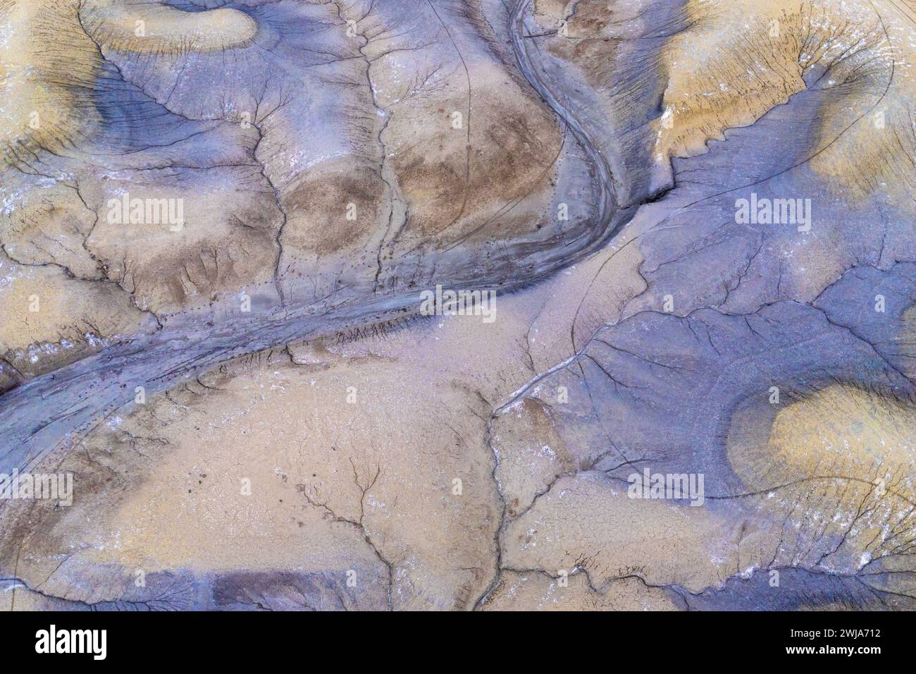 Vue aérienne de motifs désertiques abstraits avec un lit de rivière sec serpentant à travers un terrain sablonneux texturé dans l'Utah, États-Unis Banque D'Images