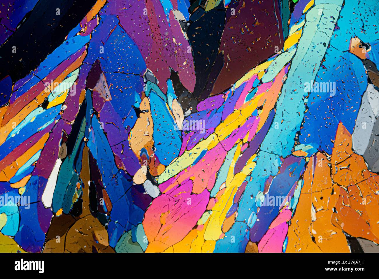 Une vue microscopique fascinante des cristaux de sucre d'érythritol avec un éclat brillant de couleurs contrastées et de surfaces texturées Banque D'Images