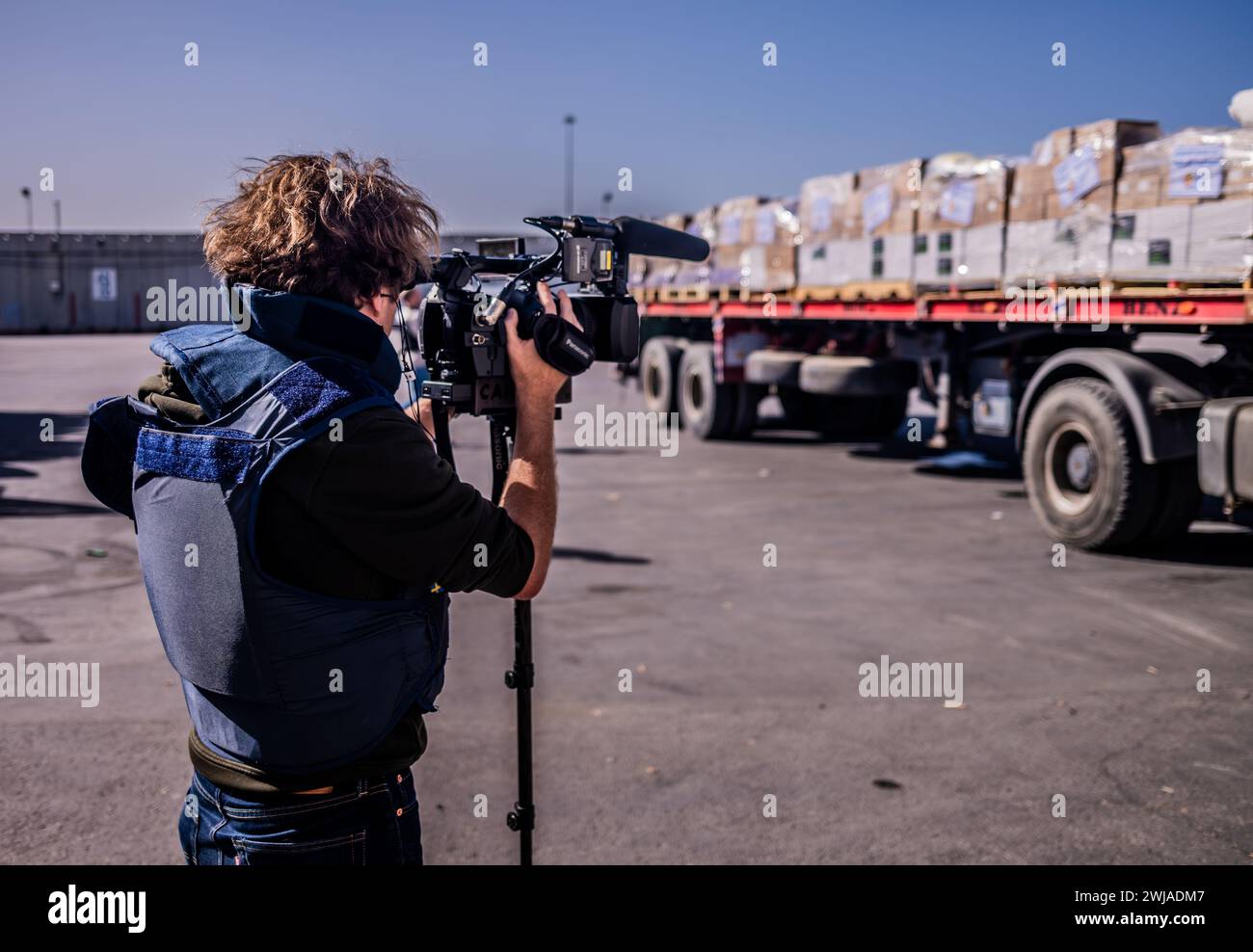 Un journaliste avec une caméra capturant des images d'un camion d'aide humanitaire à Kerem Shalom, Israël Banque D'Images