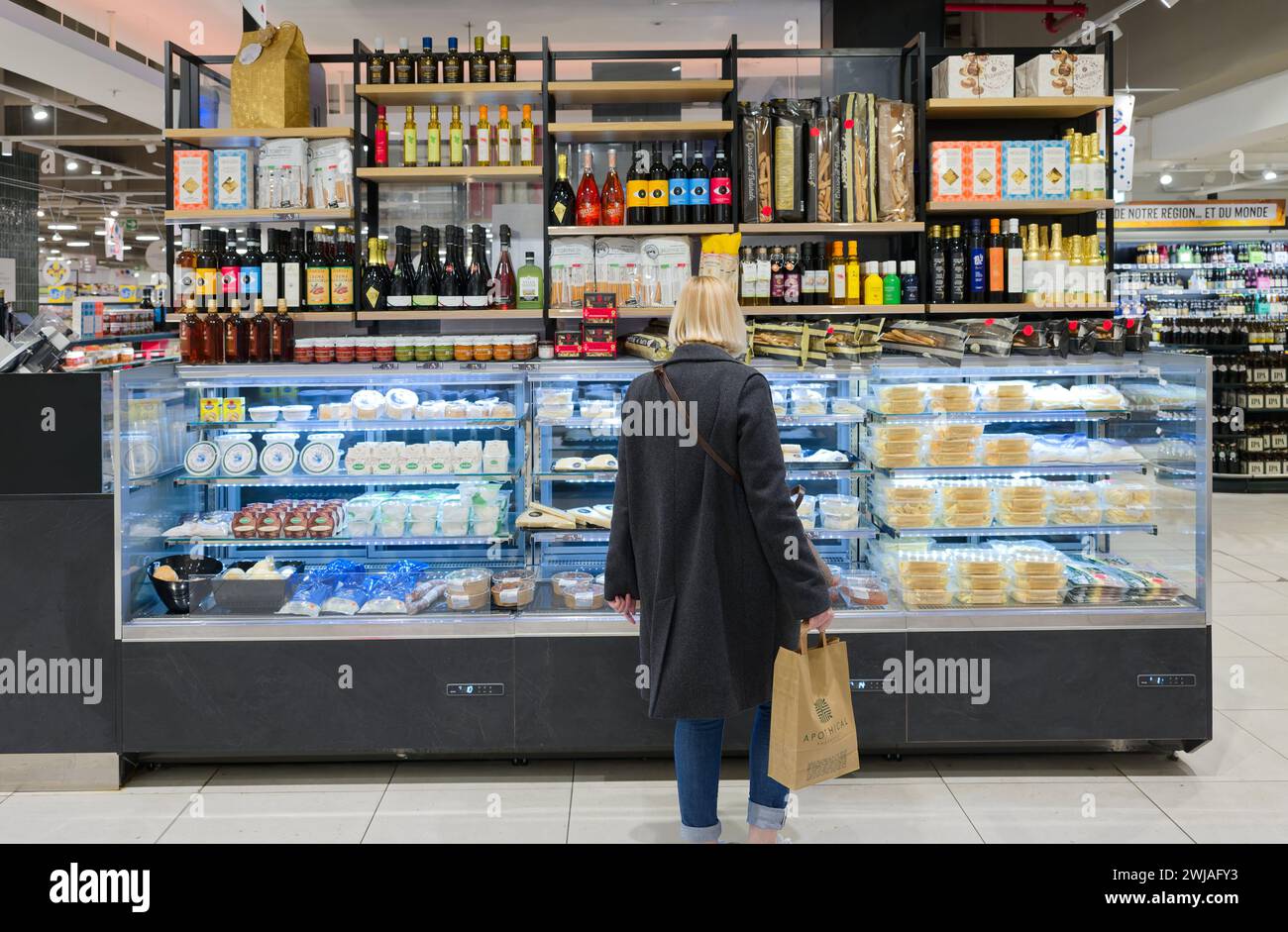 Femme dans une section d'un supermarché Monoprix dans le centre commercial Cap 3000 à Saint-Laurent-du-Var (sud-est de la France). Fromage et produits frais Banque D'Images