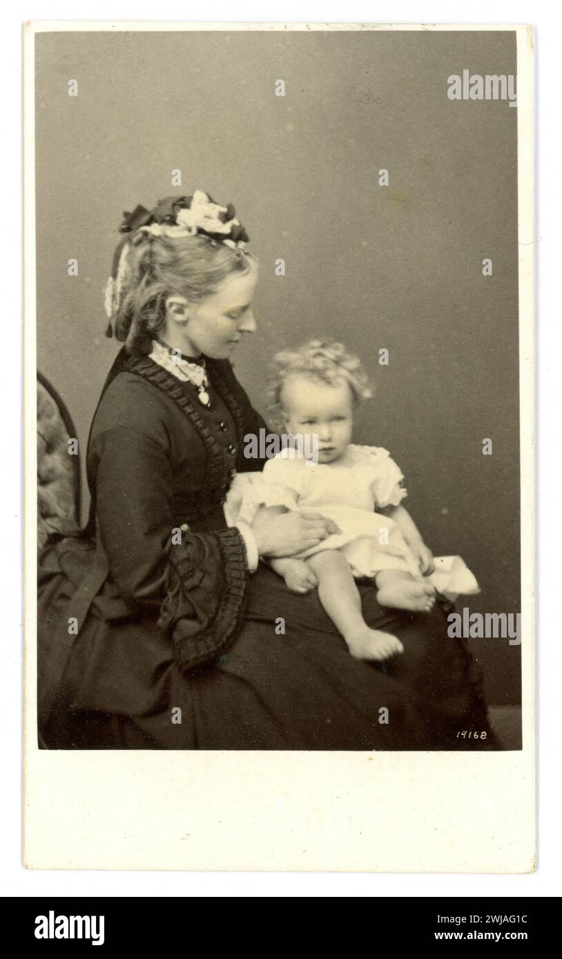 Original très clair, magnifique, image de qualité du victorien CDV carte de visite (carte de visite ou CDV) d'une belle femme galloise aristocartique, mère victorienne, avec un enfant mignon sur ses genoux, wearomg une petite casquette avec un haristyle élaboré. Extrait de la collection du château de Hampton court de la famille Arkwright, Hereford c. 1870 d'exact Hat and Hair in la mode Illustree daté de 1870. Banque D'Images