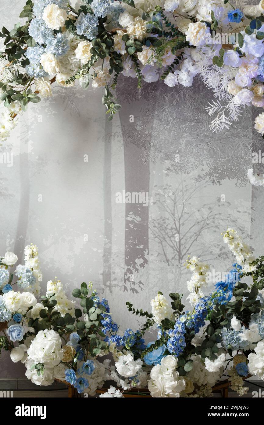 Arc de fleurs et de verdure sur un fond d'un mur gris, espace de copie. Fond floral. Gabarit, vierge pour une carte postale. Journée internationale de la femme, Banque D'Images