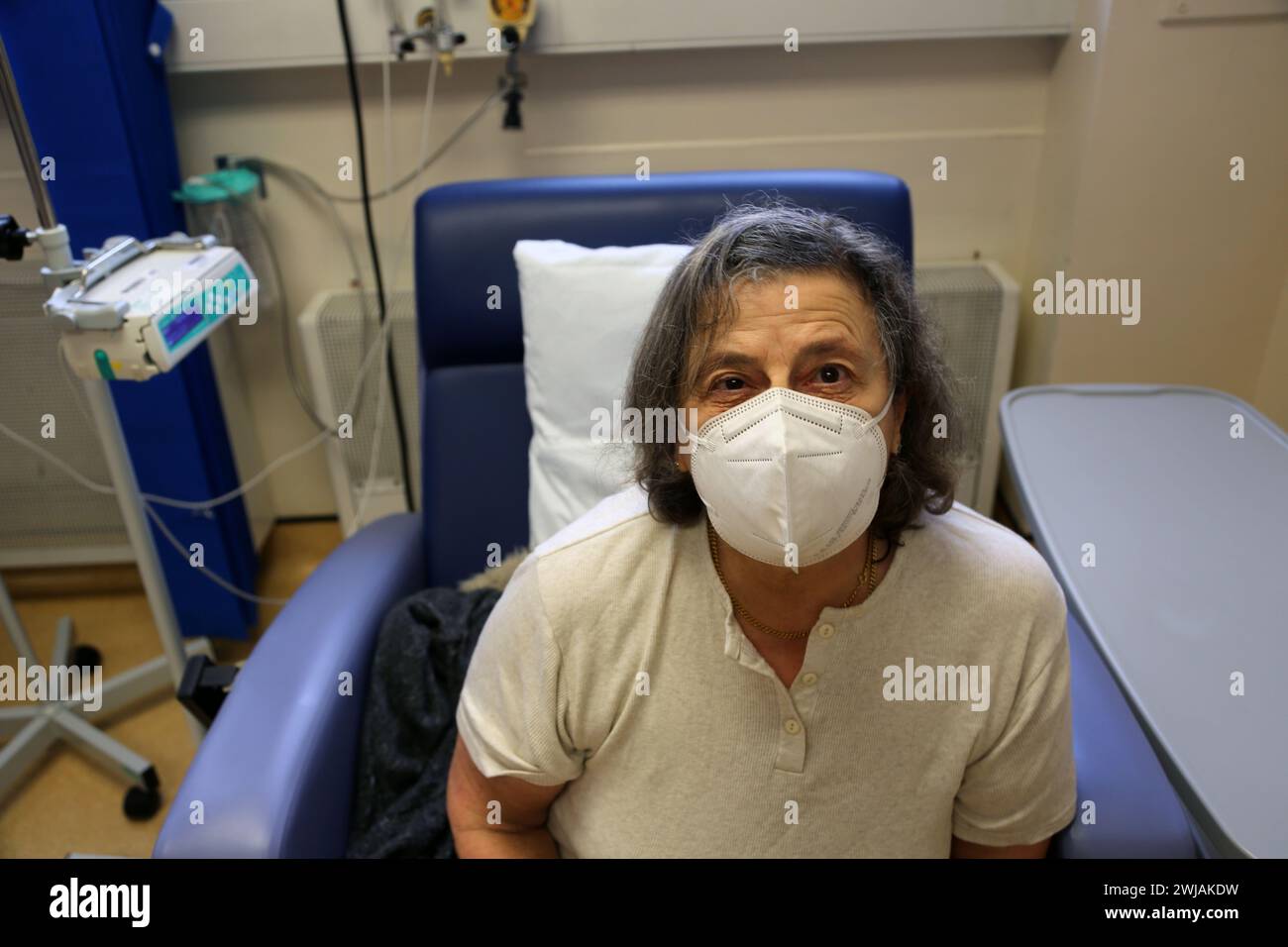 Un patient anémique portant un masque facial en attente d'une perfusion de fer à l'hôpital Surrey Angleterre Banque D'Images