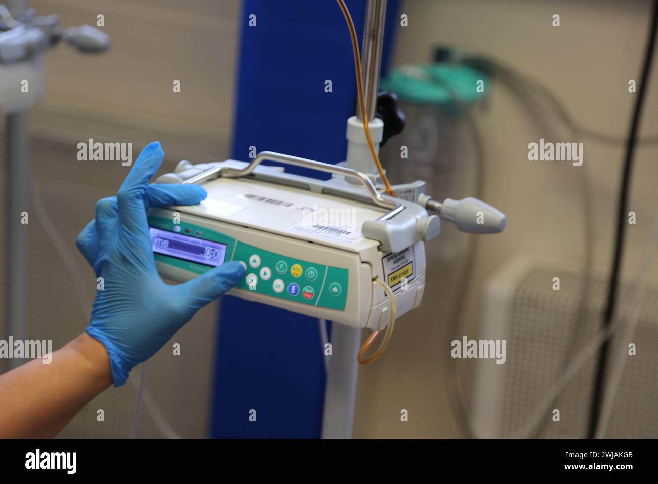 Infirmière préparant le système de pompe à perfusion volumétrique Infusomat Space prêt pour une perfusion de fer sur un patient à l'hôpital Surrey Angleterre Banque D'Images