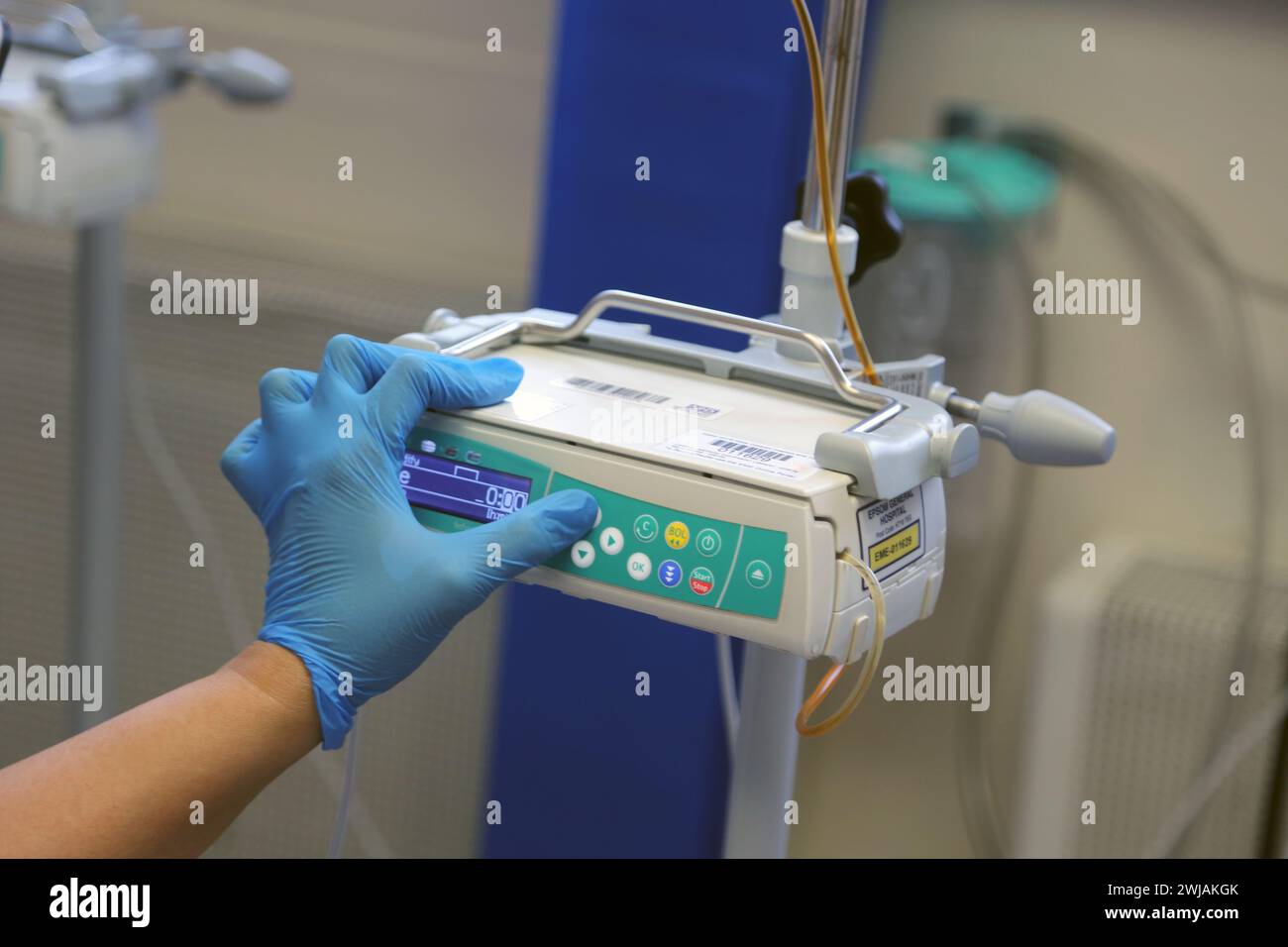 Infirmière préparant le système de pompe à perfusion volumétrique Infusomat Space prêt pour une perfusion de fer sur un patient à l'hôpital Surrey Angleterre Banque D'Images