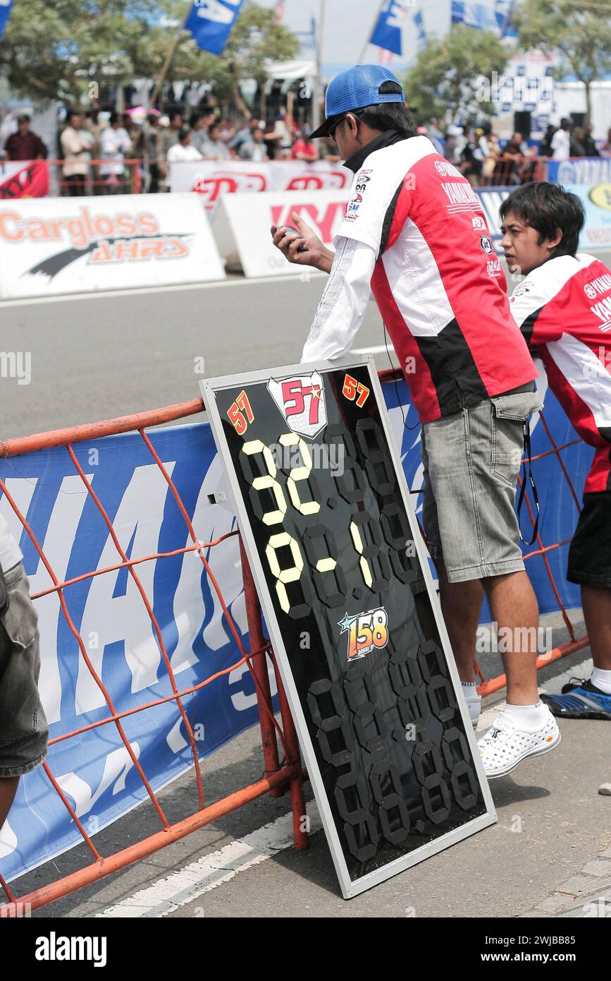 L'équipe de course observe un chronomètre avec un message sur le tableau de commande de la fosse à côté du circuit de course de motos à Kediri, Java oriental, Indonésie Banque D'Images