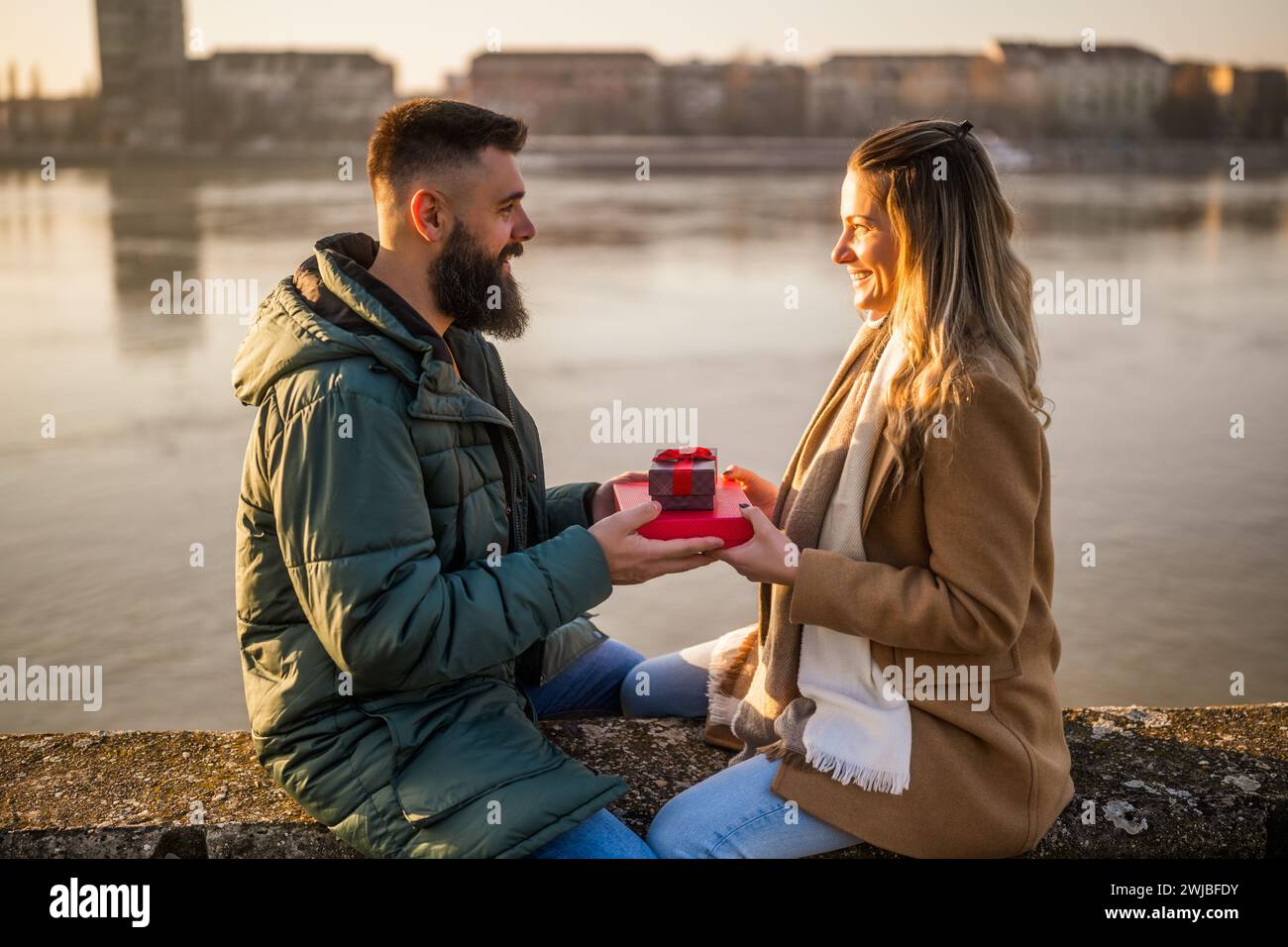 Homme donnant des cadeaux à sa femme pendant qu'ils aiment passer du temps ensemble à l'extérieur. Banque D'Images