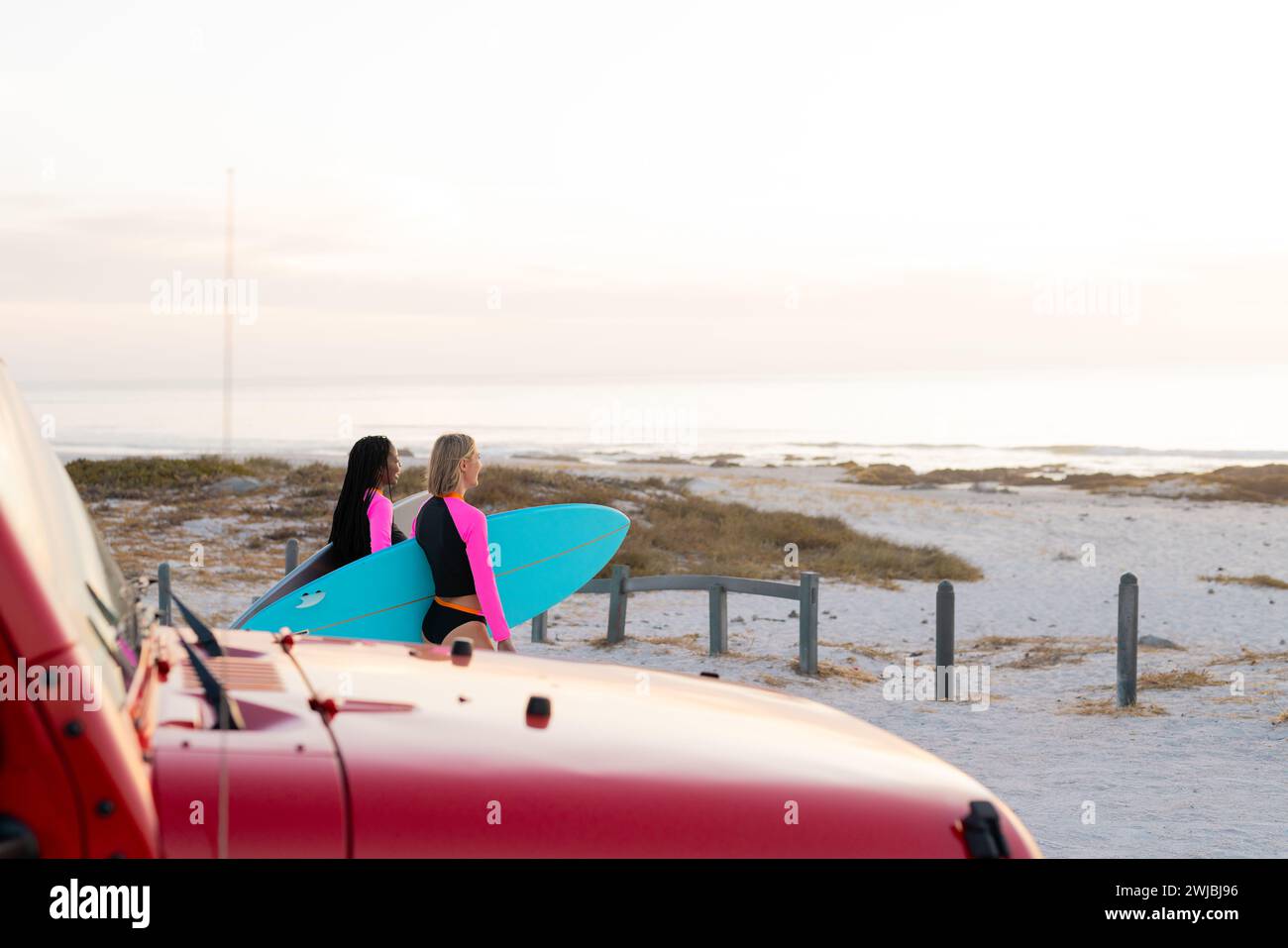 Deux femmes avec des planches de surf se préparent pour une séance à la plage Banque D'Images