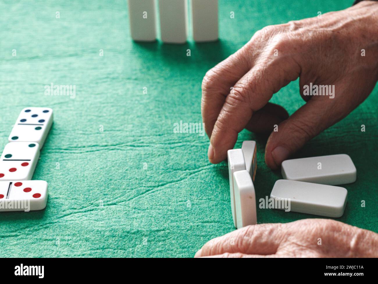 Gros plan d'une personne âgée méconnaissable avec des rides et des veines jouant un jeu de dominos Banque D'Images