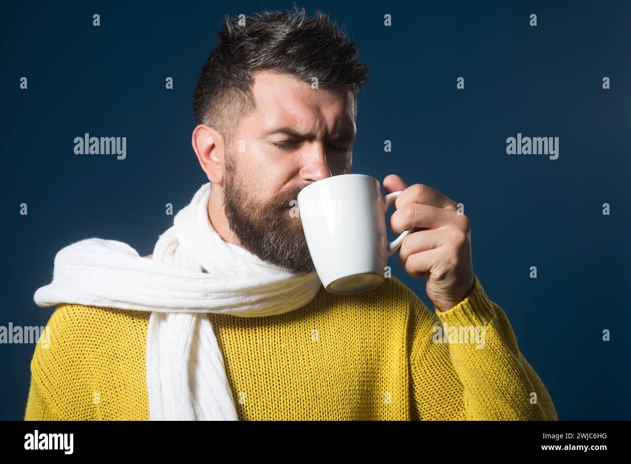 Homme barbu appréciant une tasse de thé chaud dans un café. Satisfait homme attrayant buvant boisson chaude. Pause café. Beau mâle avec barbe et moustache Banque D'Images