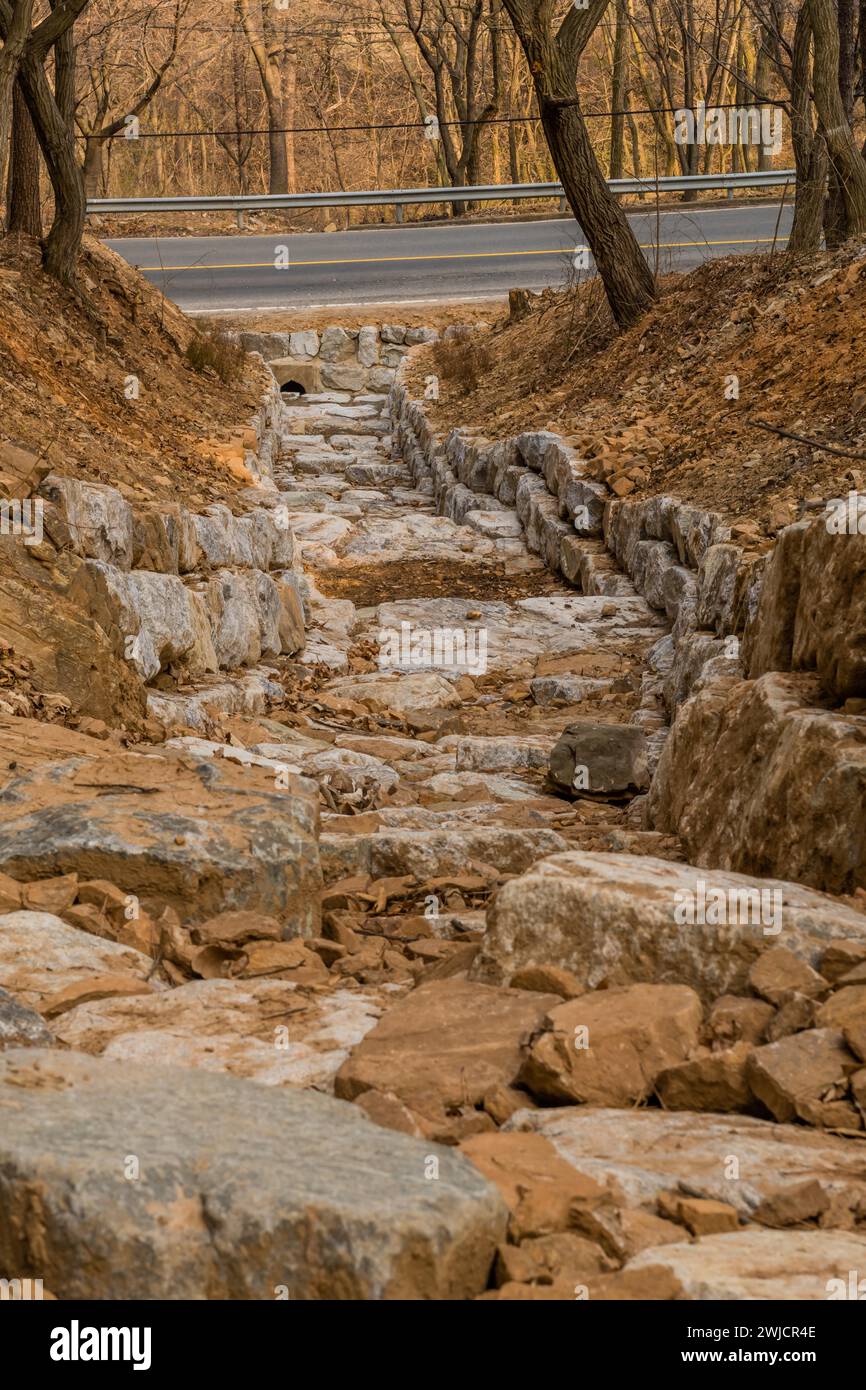 Fossé de drainage construit de gros rochers sur le flanc de la montagne au début de l'après-midi de printemps en Corée du Sud Banque D'Images
