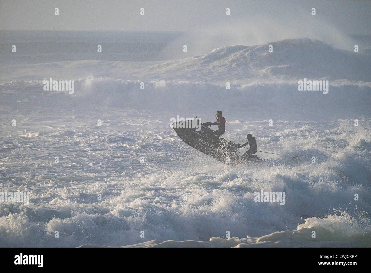 Jet ski saut au-dessus d'une vague dans l'océan Atlantique orageux, Nazare, Portugal Banque D'Images