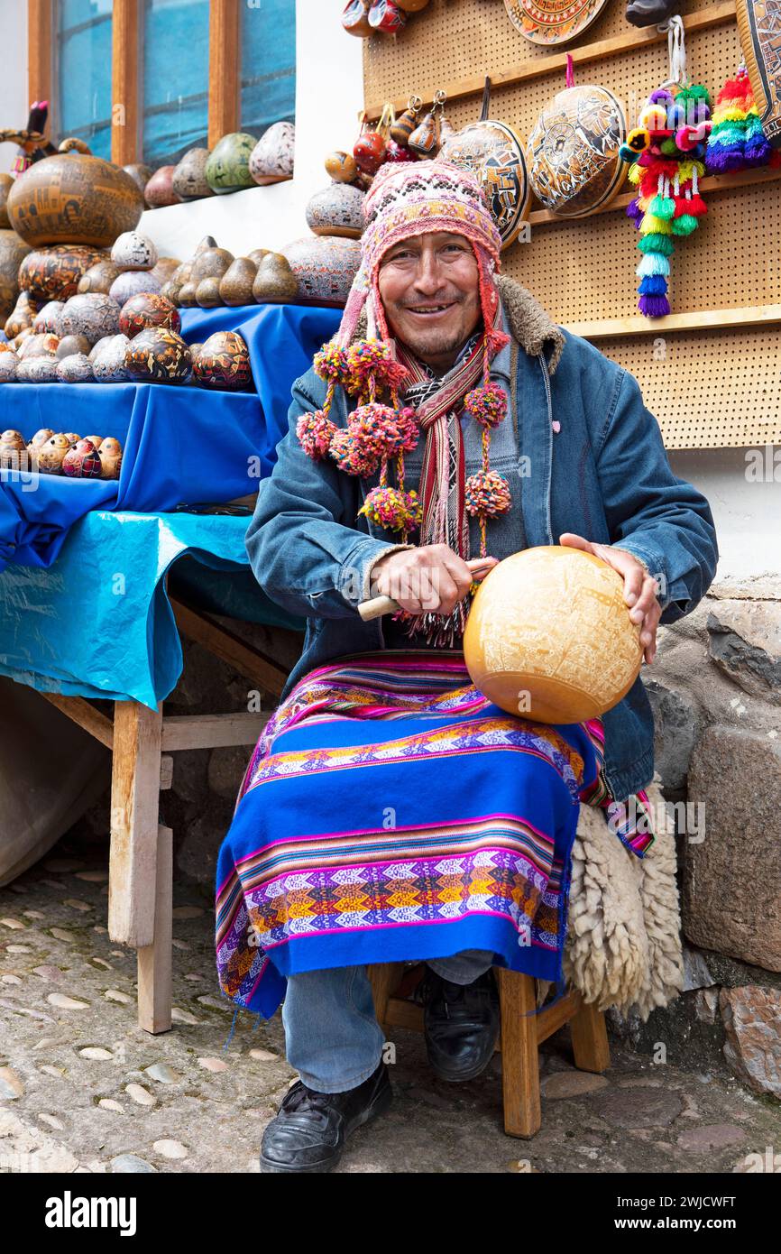 Homme péruvien avec casquette traditionnelle et compagnons burilados ou gourdes gravées, Chinchero, région de Cusco, Pérou Banque D'Images