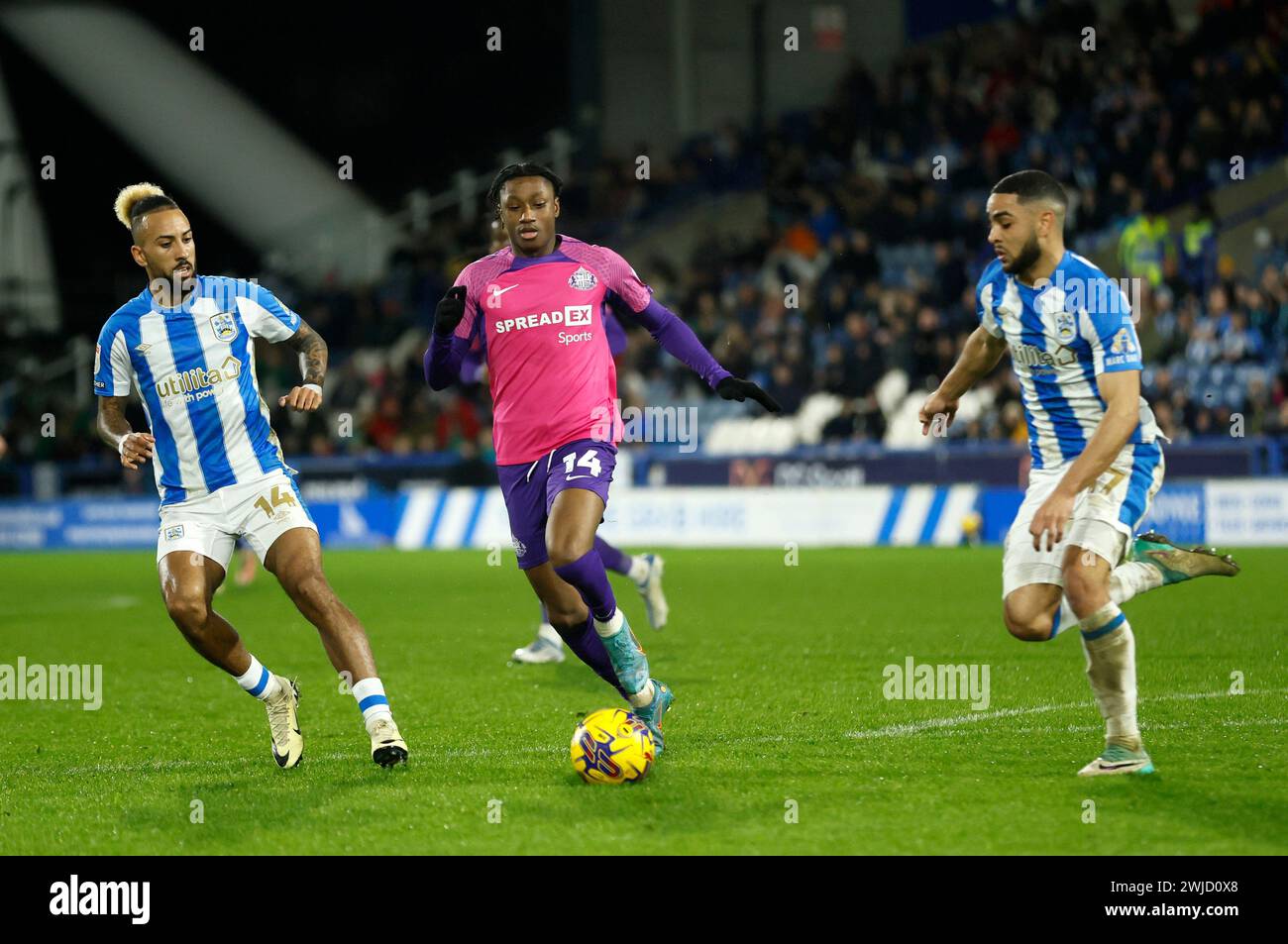 Sorba Thomas de Huddersfield Town, Ross Stewart de Sunderland et Brodie Spencer de Huddersfield Town se battent pour le ballon lors du Sky Bet Championship match au John Smith's Stadium, Huddersfield. Date de la photo : mercredi 14 février 2024. Banque D'Images