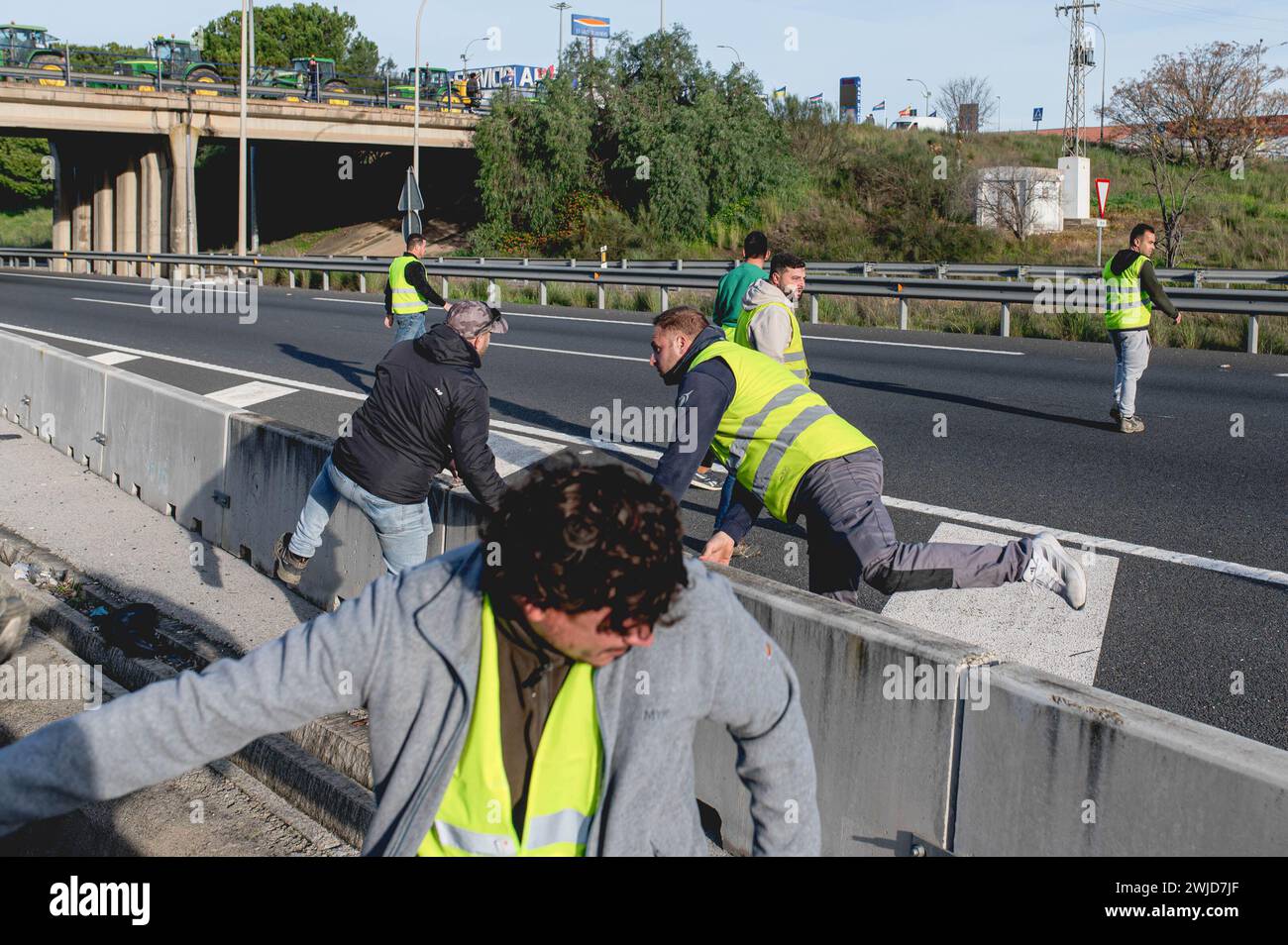 Des groupes de manifestants sont vus attaquer l'autoroute dans les deux sens, arrêtant la circulation sans l'autorisation des autorités pendant la manifestation des agriculteurs andalous ont bloqué toutes les autoroutes menant à la ville de Séville. Ces protestations sont en partie encouragées par les syndicats et les organisations agricoles de l'extrême droite espagnole, qui ont trouvé une solution aux problèmes des agriculteurs et ont ensuite exercé des pressions sur le gouvernement. Ces manifestations ont lieu en Espagne depuis le 6 février en réponse aux manifestations en France, où les agriculteurs se plaignent de la concurrence déloyale des produits provenant de sociétés non européennes Banque D'Images