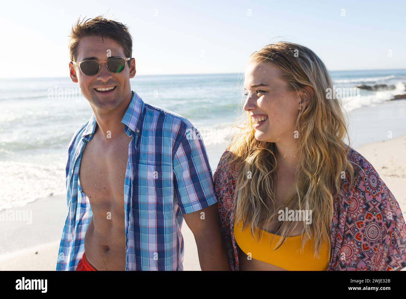 Un couple caucasien profite d'une journée ensoleillée à la plage Banque D'Images
